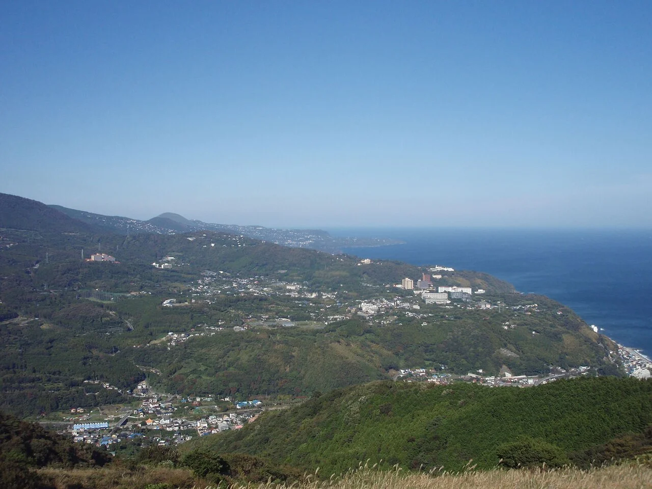 Green Higashiizu hills and coastal settlements above the sea